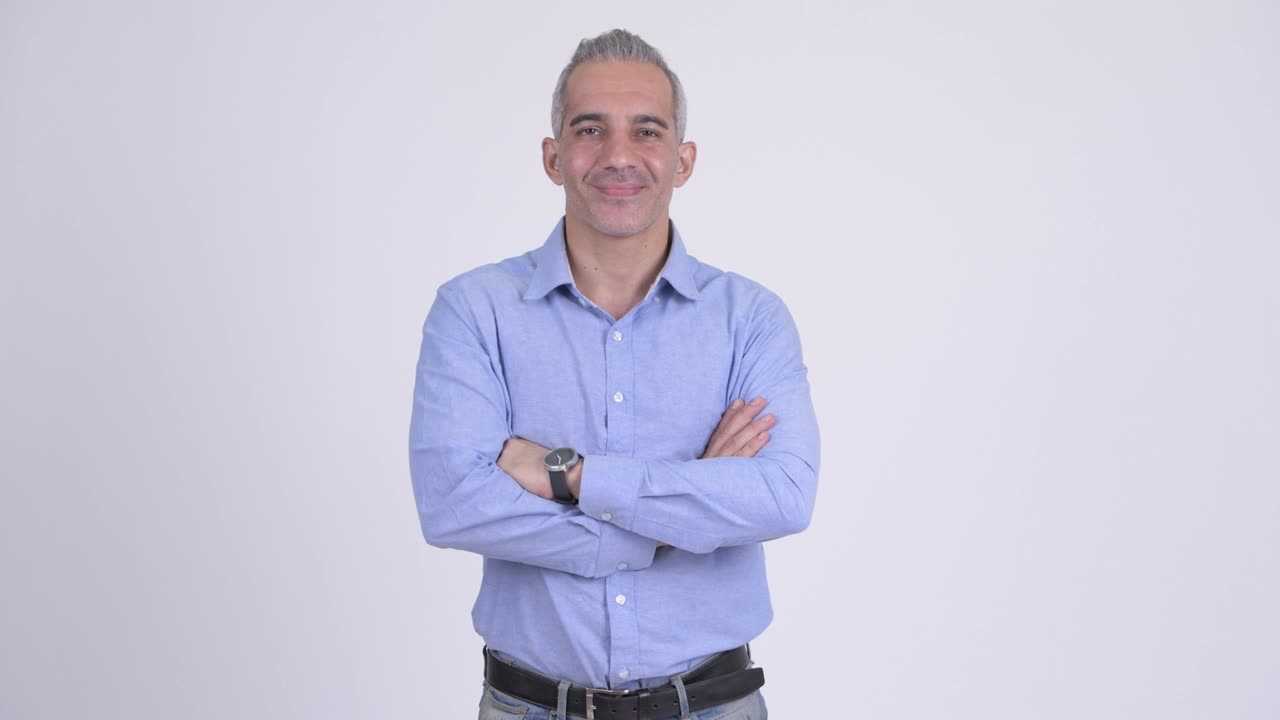 Happy mature Persian businessman with arms crossed
