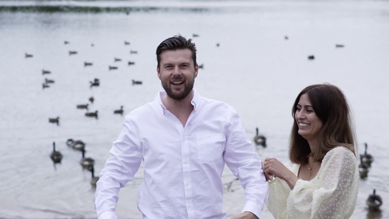 Husband joking around with his wife with ducks on the background.