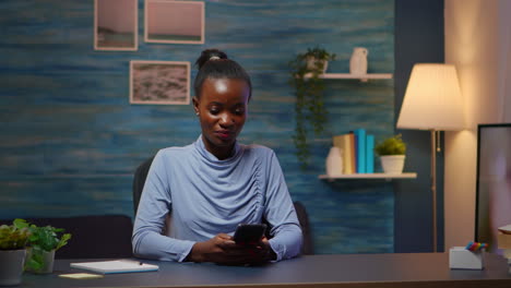 Señora-Africana-Tomando-Un-Descanso-Escribiendo-En-El-Teléfono-Inteligente