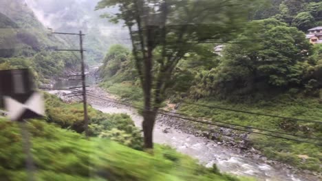 japanese mountain train moves along the course of the river