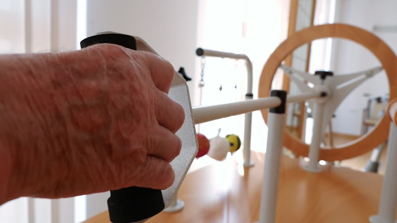 Close-up of a hand performing wrist rotation on a rehabilitation machine. Physiotherapy for osteoarthritis and mobility at a senior center. Occupational therapy to regain strength and rotation