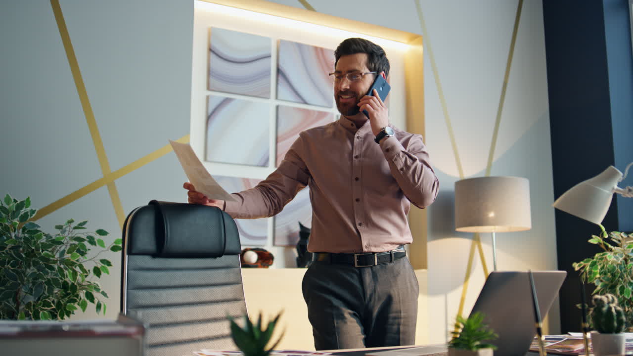 Successful company owner calling mobile phone standing office. Manager talking