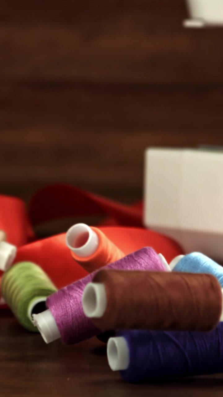 Colorful Spools of Sewing Thread Falling in Slow Motion