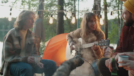 Chicas-Tocando-La-Guitarra-Y-Cantando-Junto-A-La-Fogata