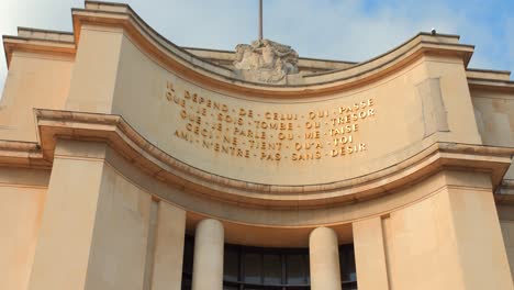 Low-angle-shot-of-Trocadero-left-right-wing-writings-in-Paris,-France-during-evening-time