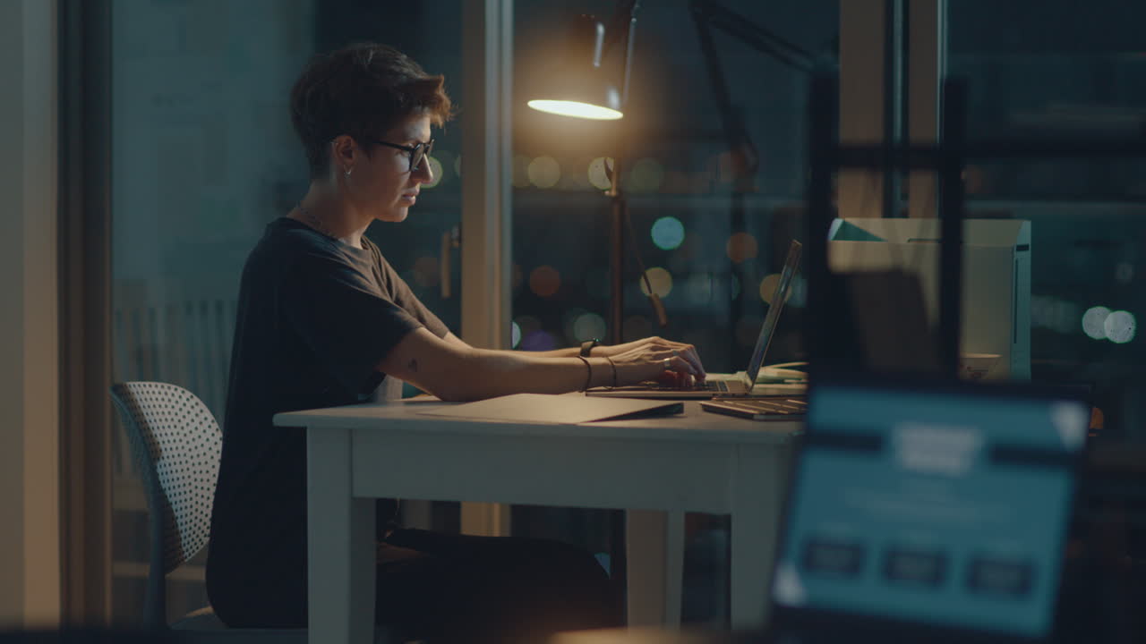 Donna che usa un laptop in ufficio di notte