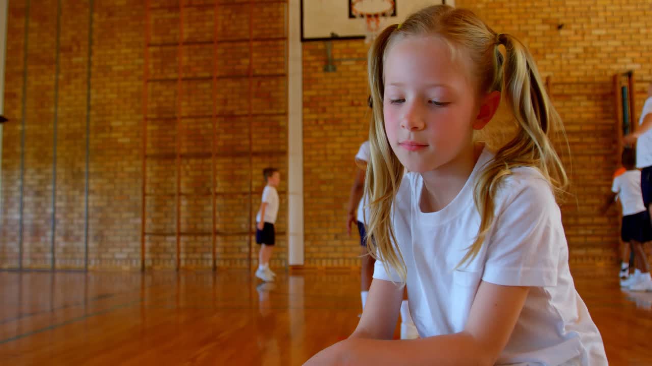 Schoolgirl relaxing in basketball court at school 4k