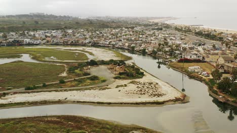 A-wide-aerial-shot-of-the-ocean-coastline-zooms-in-to-reveal-a-set-of-oil-pumpjacks