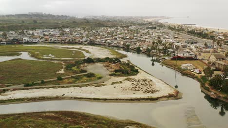 una amplia toma aérea de la costa del océano se acerca para revelar un conjunto de bombas de aceite