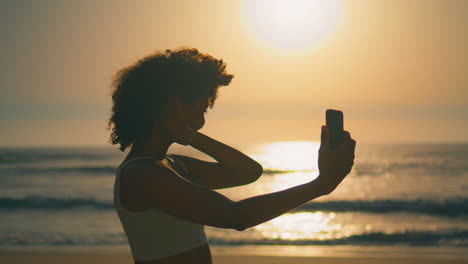 Mujer-Sonriente-Haciendo-Selfie-Al-Amanecer-En-El-Primer-Plano-De-La-Playa-De-Ursa.-Chica-Posando-Cámara