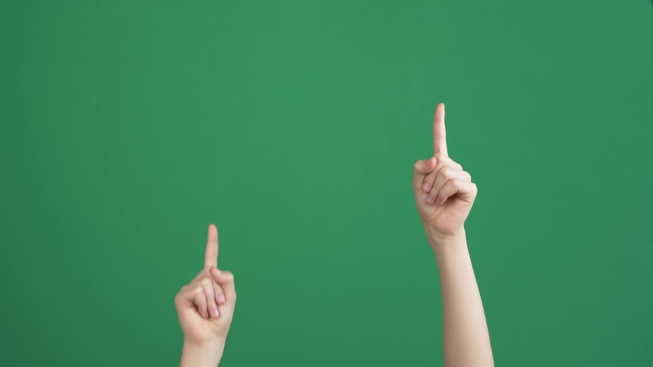 아이의 손을 높이고 손가락을 빈 크로마 키를 위로 가리키며 녹색 스크린 배경으로 대화, 제스처 개념이 없습니다.