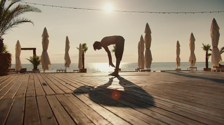 Yogi guy gets on his hands during his yoga class on the salty beach. Yoga and zen style