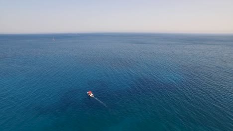 Ein-Kleines-Boot-Auf-Dem-Kristallklaren-Wasser-In-Der-Nähe-Des-Oasi-Strandes-Bei-Den-Keri-Höhlen,-Zakynthos,-Luftaufnahme