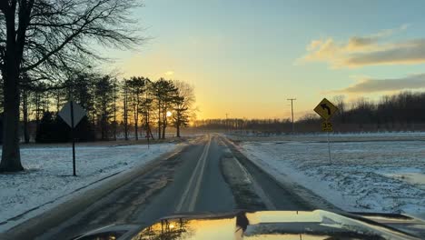 country road sunset during winter, cold snow covered landscape during sunset