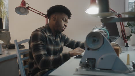 man working on a sewing machine in a workshop