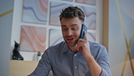 Closeup excited winner calling mobile phone sitting office. Happy businessman