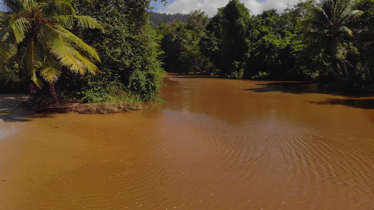 imágenes aéreas de un río que se encuentra con el mar en la bahía de las cuevas ubicada en la isla caribeña de trinidad