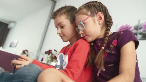 children playing mobile games on smartphone at home. boy playing video game