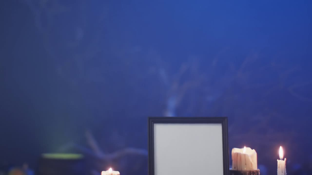 video de un marco con espacio de copia, tela de araña, cráneo y velas sobre fondo azul