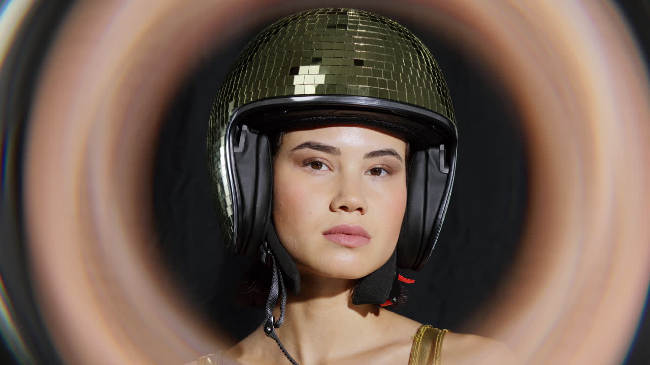 여성이 거울 공 토끼 귀로 포즈를 취합니다.