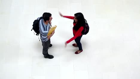 two students chatting and hugging in the hallway