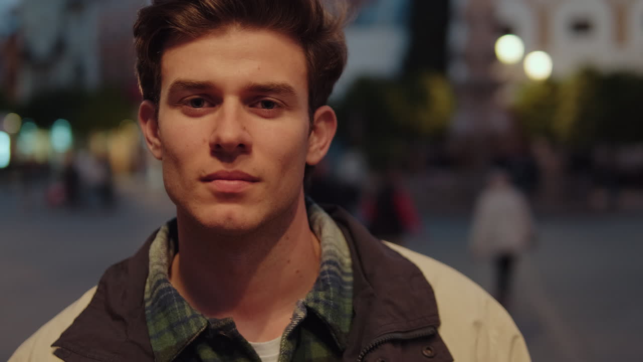 Stylish Young Man Smiles in City Square at Night