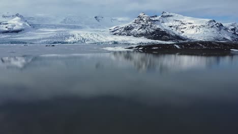 montañas rocosas nevadas a orillas del lago en el día de invierno