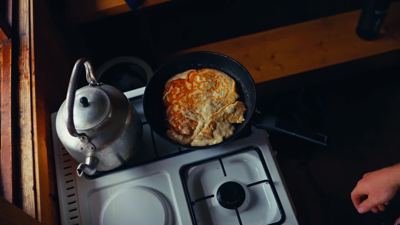 Cropped View Of A Person Cooking Omelet In A Pan Over A Stove. High Angle Shot