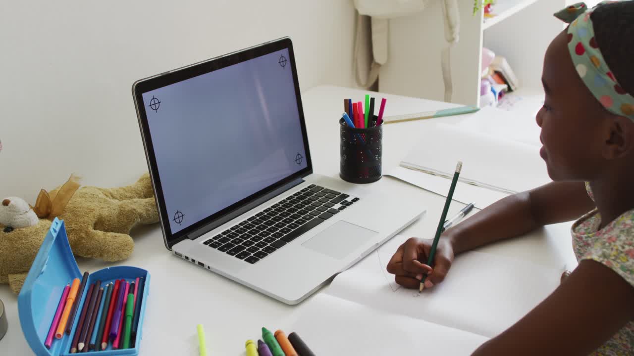 African american girl doing homework looking at laptop with copy space at home