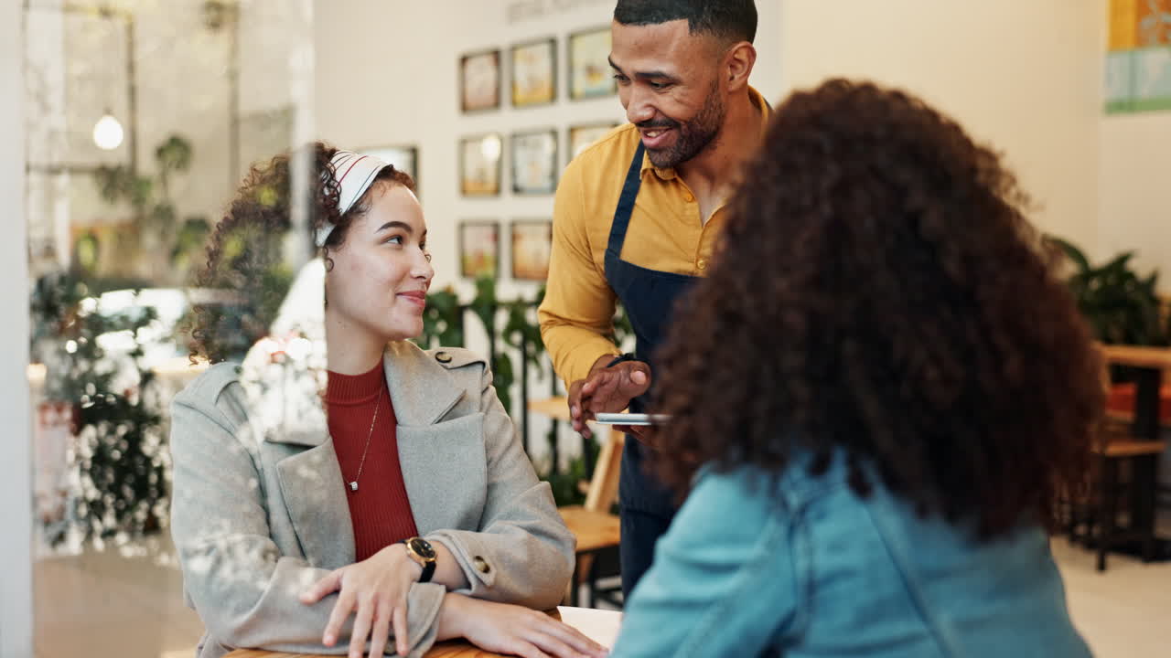 Waiter taking order from customers in cafe