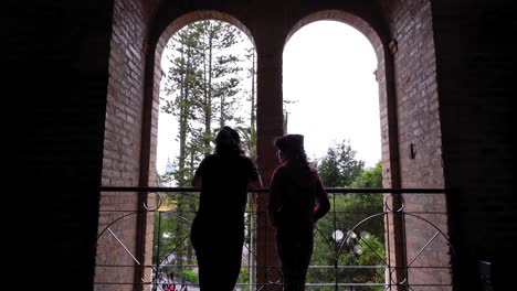 man and woman looking out over the city from a tower