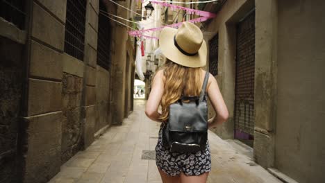 4k video footage of an unrecognisable woman walking alone through the streets of barcelona