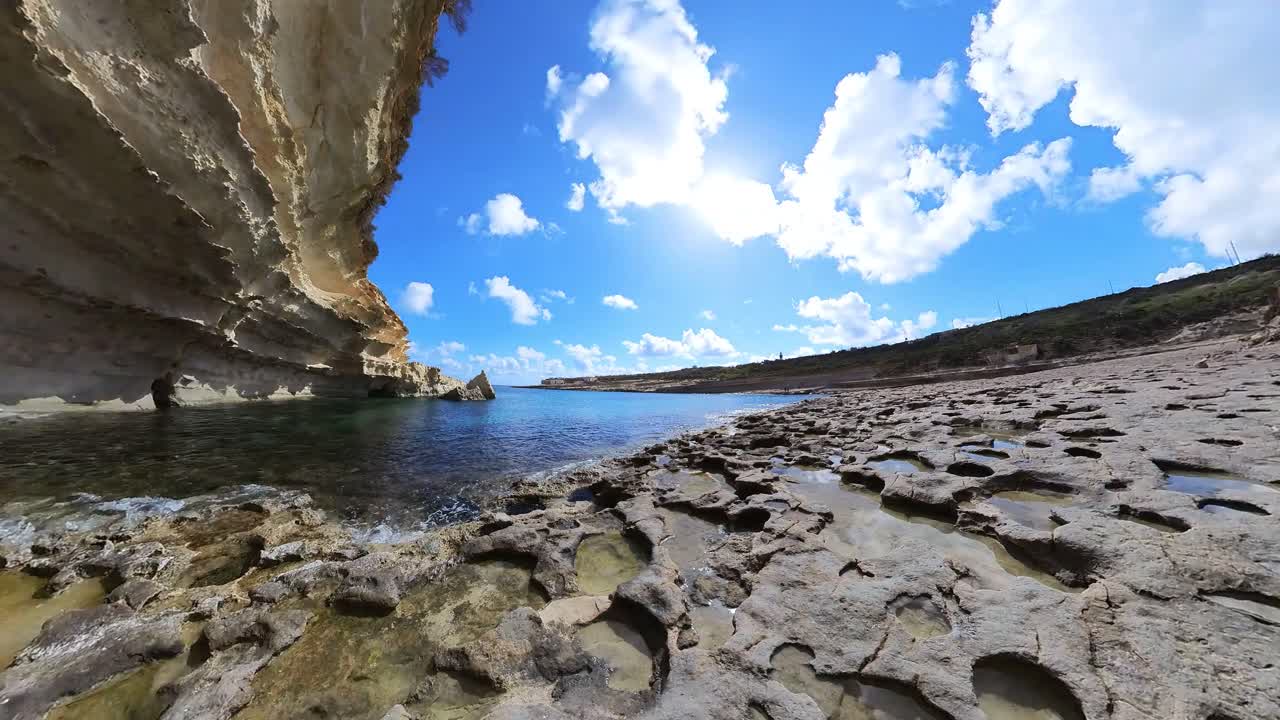 lapso de tiempo de la playa de il-kalanka en malta con agua turquesa, cielo azul y nubes blancas esponjosas