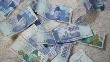 Los-Billetes-De-La-Moneda-Pakistaní-Están-Cayendo-Al-Suelo---Primer-Plano-De-Los-Billetes-De-1000-Y-500-Pkr-Cayendo