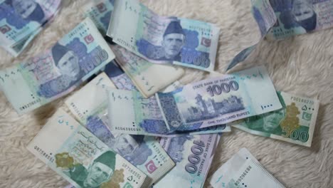 los billetes paquistaníes están cayendo al suelo: primer plano de billetes de 1000 y 500 pkr cayendo