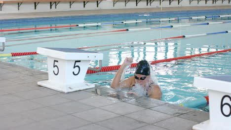 caucasian woman finishes a swim lap at the pool