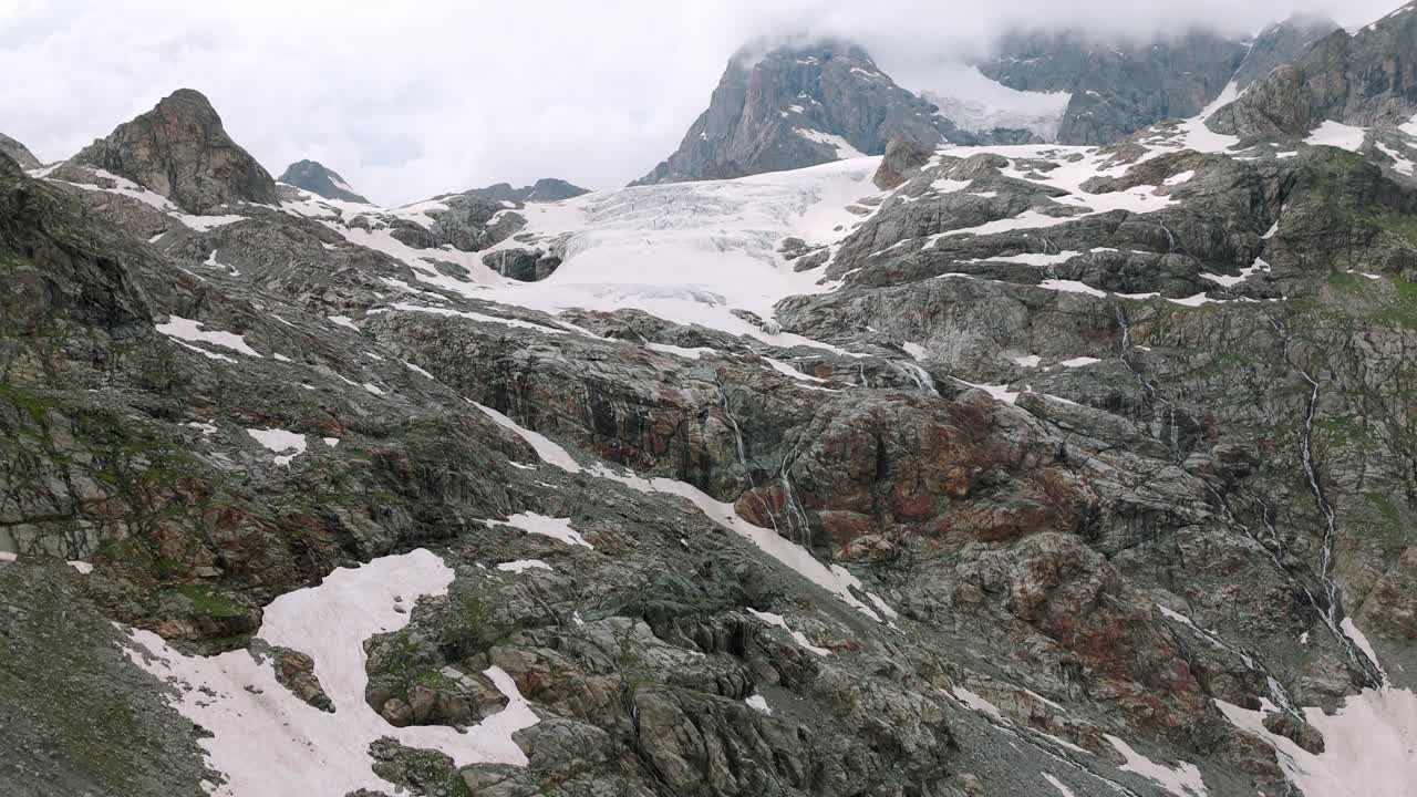 Alpes de Valmalenco, Lombardia, Itália - Os picos acidentados, adornados com manchas de neve - Imagem aérea de drone.