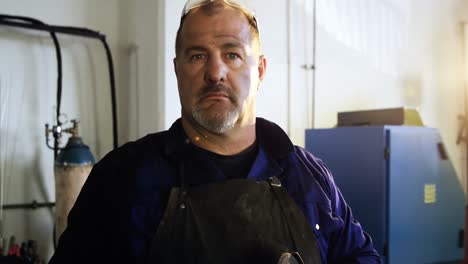 welder holding electric saw in workshop