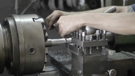 men's hands with a vernier caliper measuring the size of the details at work piece on lathe machine in the industrial factory. slow motion