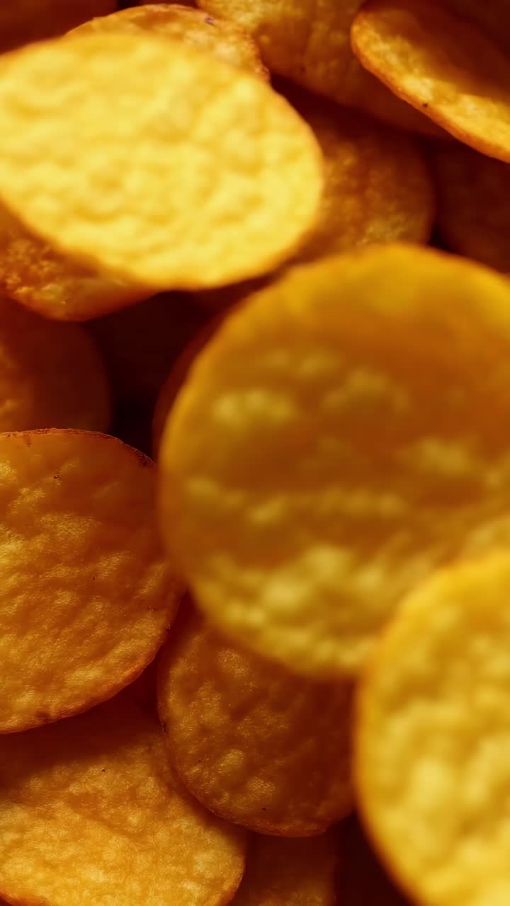 Primo piano video di patatine dorate, che mostra la consistenza e la croccantezza.