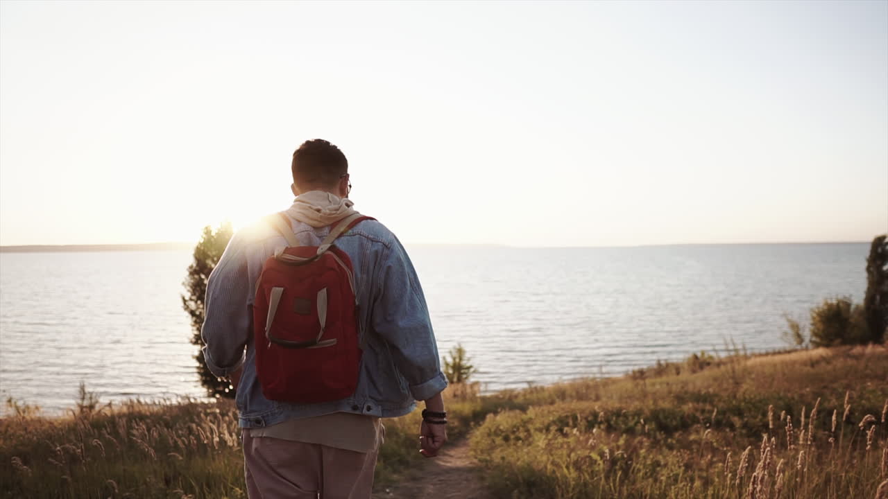 해가 지는 동안 호수 에서 산책 하는 남자