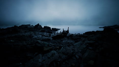 mysterious fog envelops a lonely boat on a rocky shore at twilight