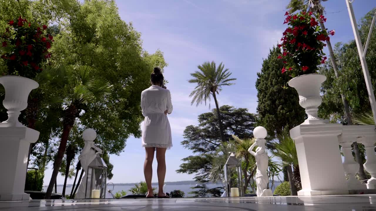 피자마 를 입은 여자 는 바다 를 바라보면서 전화 를 기다리고 있다