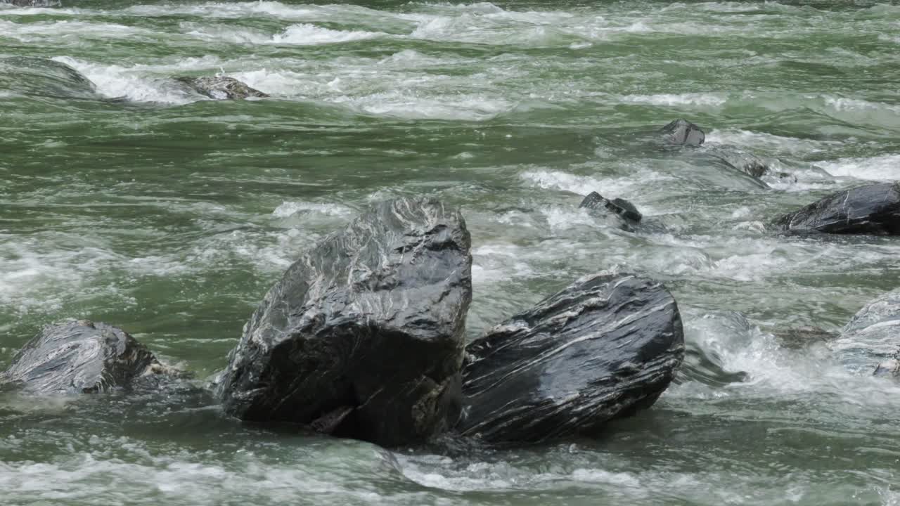 Mountain River Water Flowing Over Stone Rapids In Haast, New Zealand