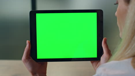 Woman-holding-mockup-pad-at-workplace-close-up.-Lady-reading-chroma-key-screen