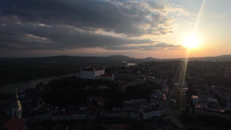 Aerial-view-of-historical-Bratislava-Castle-fortification-at-sunset,-forward