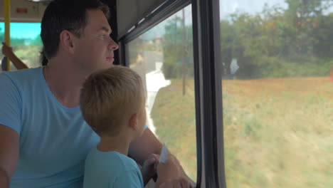 father and little son traveling by bus