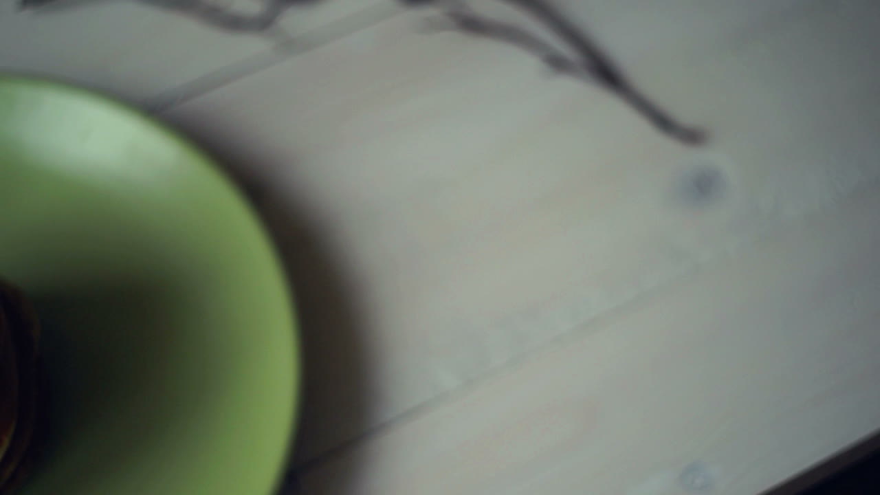 팬케이크 아침 식사. 주방 테이블에 있는 초록색 접시에 달 ⁇ 한 팬케이크  ⁇ 어리