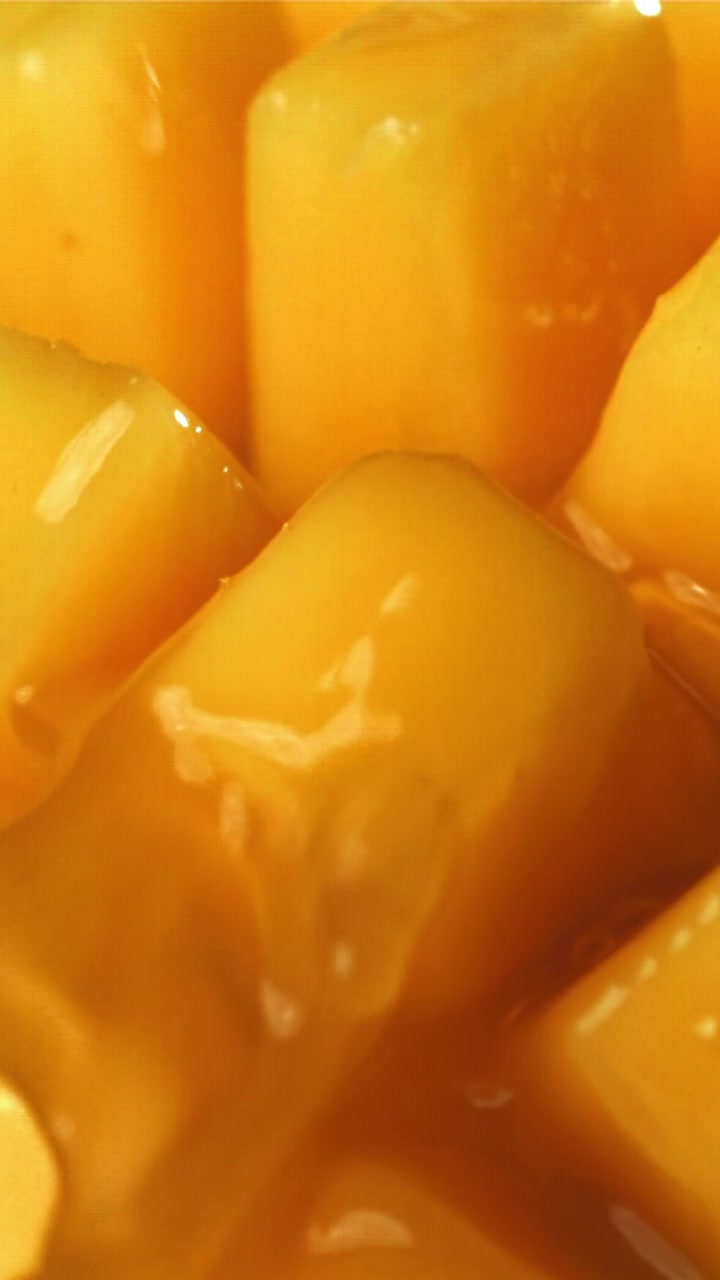 Słodki złoty syrop spływający po świeżo pokrojonym mango w kostkę