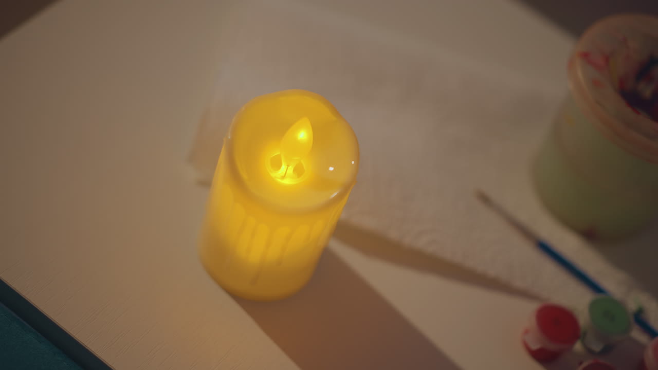 Creative Scene With Candlelight Ambiance, Vivid Overhead View Of Glowing Candle And Art Supplies, Intimate Craft Workspace Illuminated By Candle Flame And Subtle Lighting Effects With Art Tools